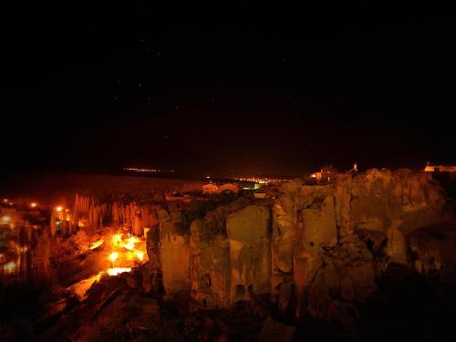 a night view of a mountain with lights on it at Kapadokya Ihlara Konaklari & Caves in Guzelyurt