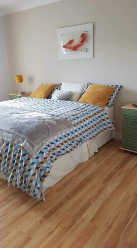 a bed in a bedroom with a wooden floor at A comfortable stay in Ballybofey in Ballybofey