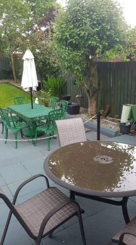 a patio with a table and chairs and an umbrella at A comfortable stay in Ballybofey in Ballybofey