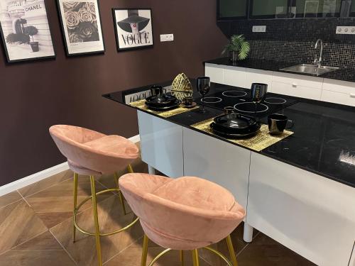 a kitchen with a counter with a stove and stools at ENZO CAPO VIP suite in Budapest