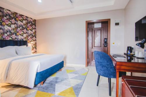 Pokój hotelowy z łóżkiem i biurkiem w obiekcie BON Hotel Garden City Port Harcourt w mieście Umudara