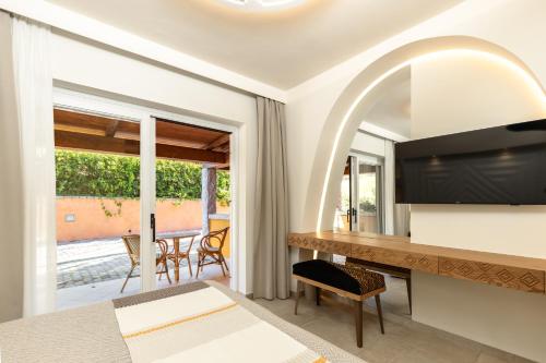 a bedroom with a bed and a desk with a mirror at Hotel Club Saraceno - Bovis Hotels in Àrbatax