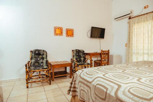 1 dormitorio con 1 cama, mesa y sillas en Palo Rosa Lodge en Puerto Iguazú