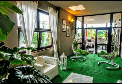 a living room with two chairs and a green carpet at Aviator Hotel Restauracja & SPA in Pabianice