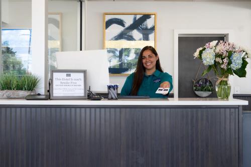 a woman is sitting at a counter in a office at Crystal Inn Eatontown in Eatontown