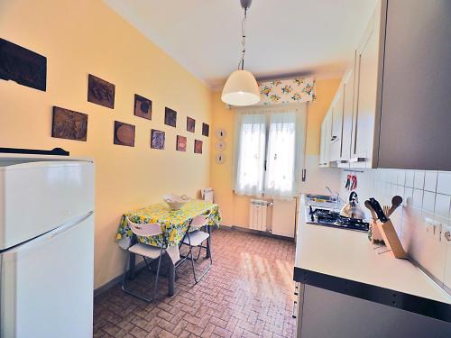 een keuken met een tafel en een keuken met een koelkast bij La Casa Di Wilde in Lerici