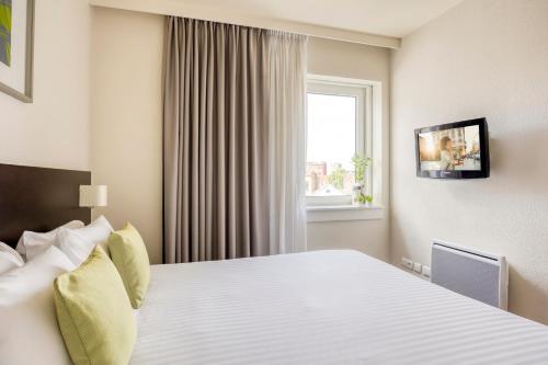 a hotel room with a bed and a window at Citadines Sainte Catherine Brussels in Brussels