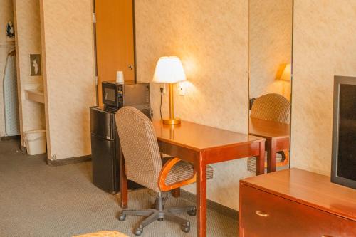 a room with a desk with a computer and a microwave at Colfax Inn By Marifah in Colfax