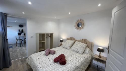 Un dormitorio con una cama con dos zapatos rojos. en Soleil Levant, en Le Crotoy