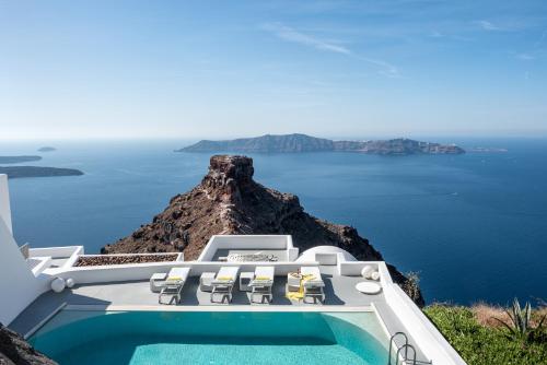 a villa with a swimming pool and a view of the ocean at Grace Hotel, Auberge Collection in Imerovigli