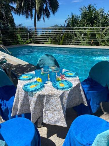 a table with food and drinks next to a swimming pool at Maison de Jardin Villa in Victoria