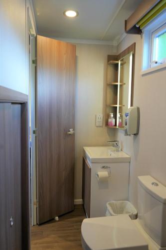 a bathroom with a toilet and a sink at Koie Smart in Stranda