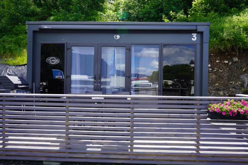 a mobile home with a porch and flowers at Koie Smart in Stranda