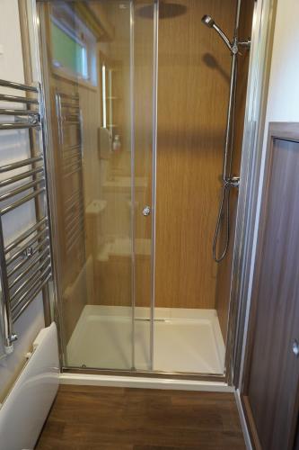 a shower with a glass door in a bathroom at Koie Smart in Stranda