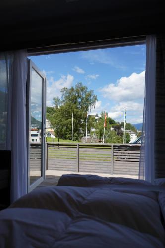 a bedroom with a bed and a large window at Koie Smart in Stranda