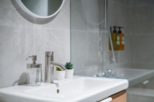 a white sink in a bathroom with a mirror at Lin Suites by Olala Homes in Taipei