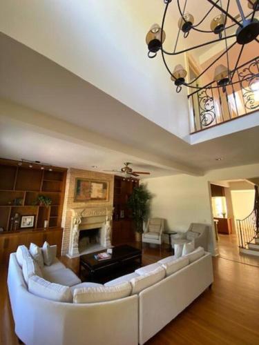 a living room with a white couch and a fireplace at The Gator Manor – 6 Bedrooms Walk to UF / Stadium in Gainesville