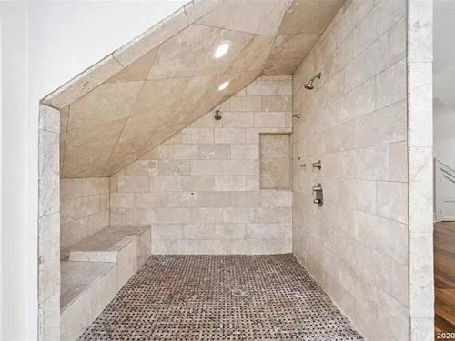 a large bathroom with a stone wall and stairs at The Gator Manor – 6 Bedrooms Walk to UF / Stadium in Gainesville