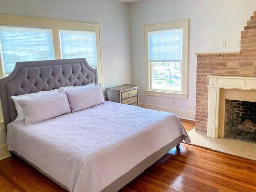 a bedroom with a large bed and a fireplace at The Gator Manor – 6 Bedrooms Walk to UF / Stadium in Gainesville