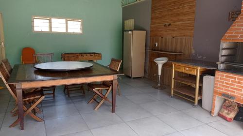 a kitchen with a table and chairs and a refrigerator at Estúdio dentro de uma chácara em Botucatu rubiao jr in Botucatu