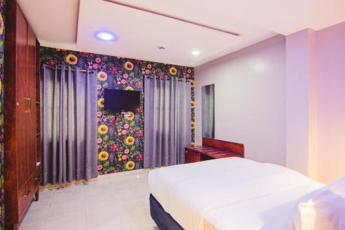a bedroom with a bed and a floral wall at White Stones Hotel Port-Harcourt in Umudara