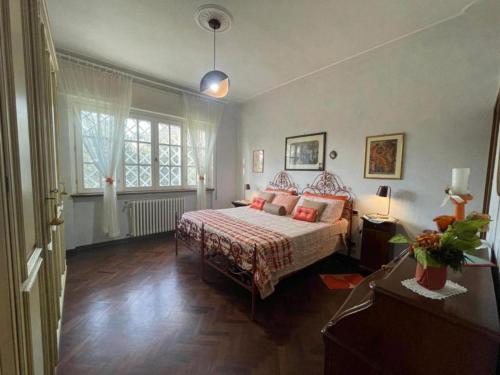 a bedroom with a bed and a large window at Villa Le Selvarelle by Nicola Real Estate in Corsanico-Bargecchia