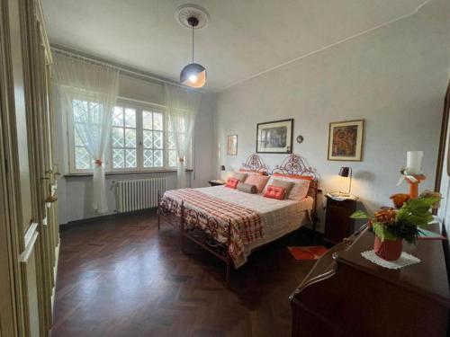 una camera da letto con un letto e una grande finestra di Villa Le Selvarelle by Nicola Real Estate a Corsanico-Bargecchia