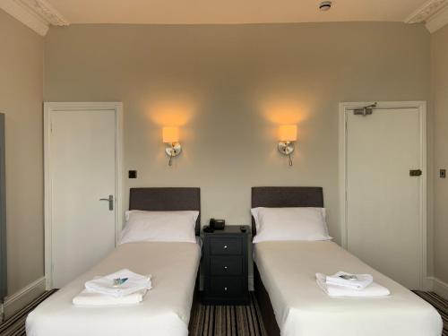 twee bedden naast elkaar in een kamer bij Arona Guest Hotel in Great Yarmouth
