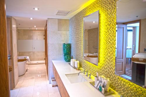 een badkamer met een wastafel en een gele tegelwand bij Real Intercontinental San Salvador, an IHG Hotel in San Salvador
