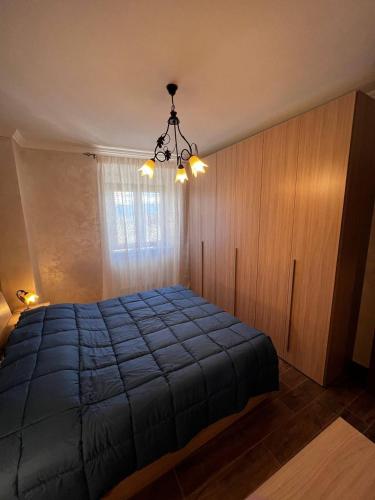 a bedroom with a blue bed and a chandelier at Da Nonna Maria in Celano