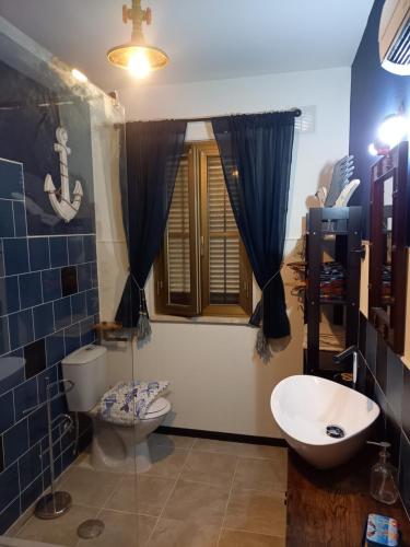 łazienka z umywalką, toaletą i oknem w obiekcie BELLA REGINA w mieście Arpino