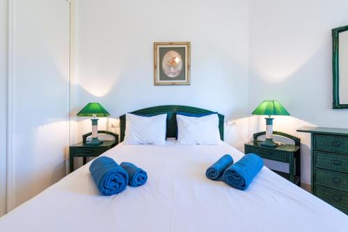 een slaapkamer met een wit bed met blauwe kussens erop bij Costa Lago Playa in Torremolinos