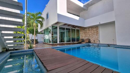een villa met een zwembad en een huis bij Casa Gem B&B in Playa del Carmen