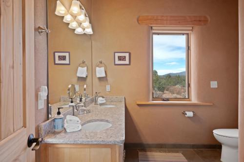 ein Bad mit einem Waschbecken, einem WC und einem Fenster in der Unterkunft Casa Cielo in Taos