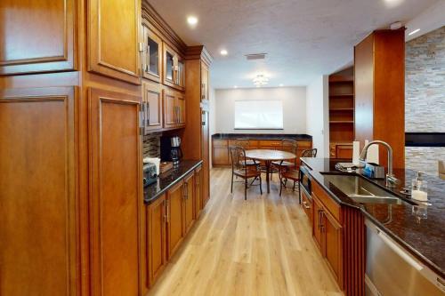 a kitchen with wooden cabinets and a table with chairs at Gator Pool and Hot Tub House -1.5 miles to Stadium in Gainesville
