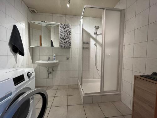 a bathroom with a shower and a washing machine at APARTMENTS RATZERSDORFER SEEN in 3100 SANKT PÖLTEN in Sankt Pölten