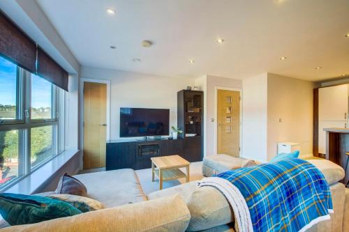 salon z kanapą i telewizorem w obiekcie GuestReady - Amazing apartment with a Castle view w Edynburgu