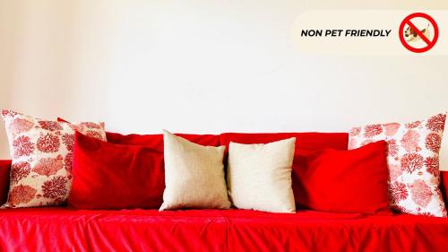 a red couch with a bunch of pillows on it at Casa in Maremma Tuscany Village in Scarlino