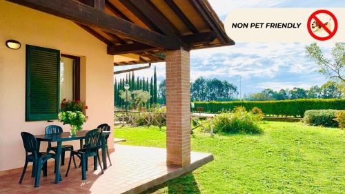 a patio with a table and chairs in a yard at Casa in Maremma Tuscany Village in Scarlino