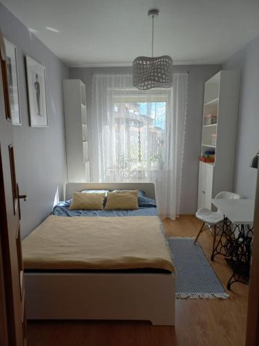 a bedroom with a bed and a window at W Krakowie u Helenki in Krakow