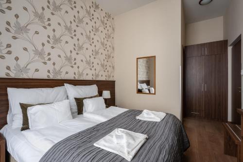 a bedroom with a large bed with white sheets at Elit Boutique Rooms- Best Location by BQA in Budapest