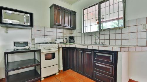 a kitchen with a white stove and a sink at Condo's Vista Al Volcan in Fortuna