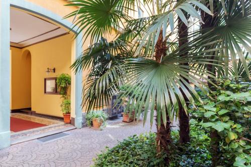 a palm tree in the courtyard of a building at Milan Retreats in Milan