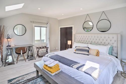 a bedroom with a large bed and two mirrors at Luxe Laguna Home with Ocean View Walk to Beach in Laguna Beach