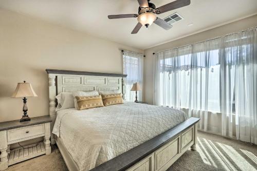 a bedroom with a bed with a ceiling fan and a window at Goodyear Desert Oasis Walk to Community Pool in Goodyear