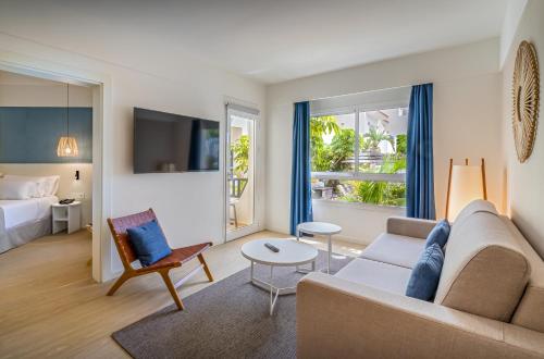 un soggiorno con un divano e un letto di Barceló Fuerteventura Royal Level a Caleta De Fuste
