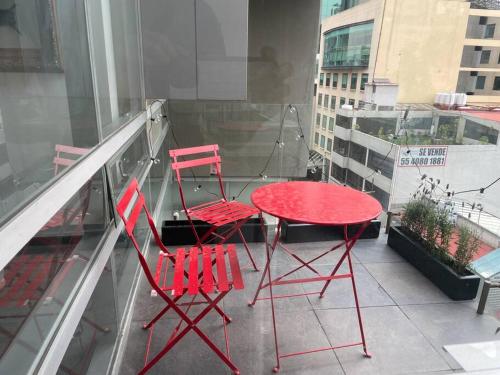 2 sillas rojas y una mesa roja en el balcón en Classy Loft near Polanco w/ balcony, en Ciudad de México