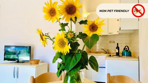 a vase filled with yellow sunflowers in a kitchen at Casa in Maremma Tuscany Village in Scarlino
