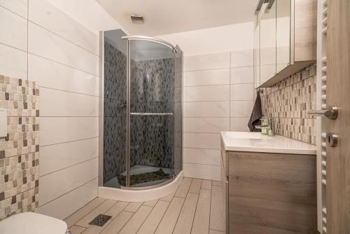 a bathroom with a shower and a sink at LTE Apartments in Maribor