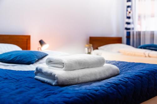 two beds with towels on top of a blue bed at Hotel Nenufar in Kościan